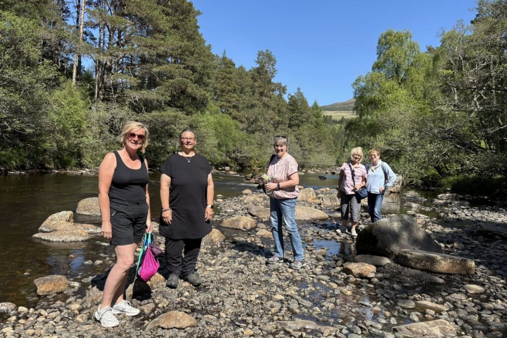 A Clarity Walk group by a Highland river